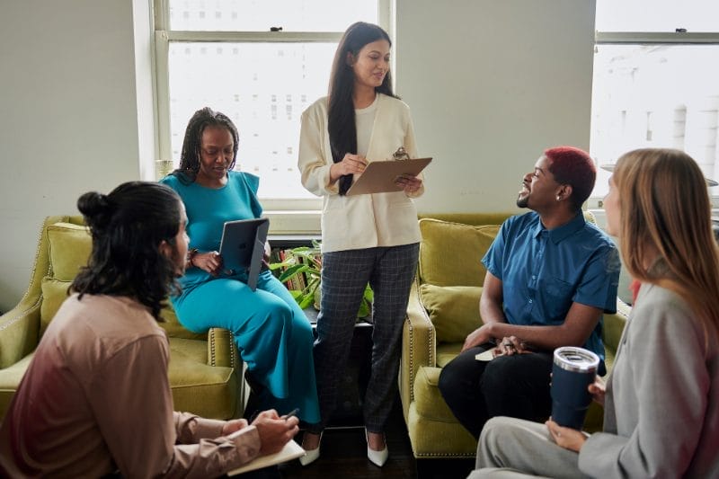 Coaching Services A diverse group engaged in a coaching session with a woman leading, representing Xseed Lead's coaching services.